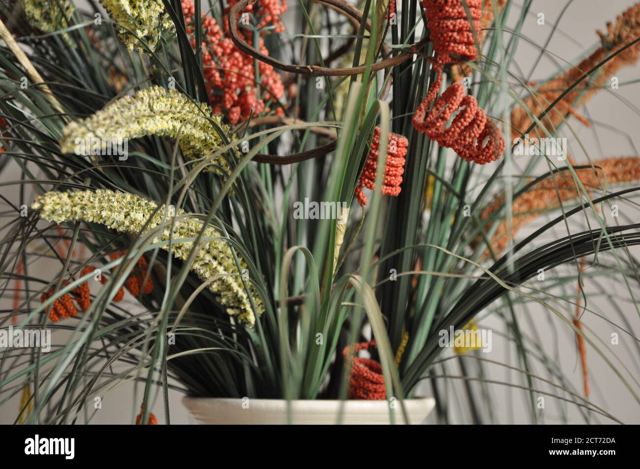 Blumenarrangement. Anordnung von bunten, unnatürlichen Blumen in Keramikvase, Foto-Zoom, mit selektivem Fokus und verschwommenem Hintergrund Stockfoto