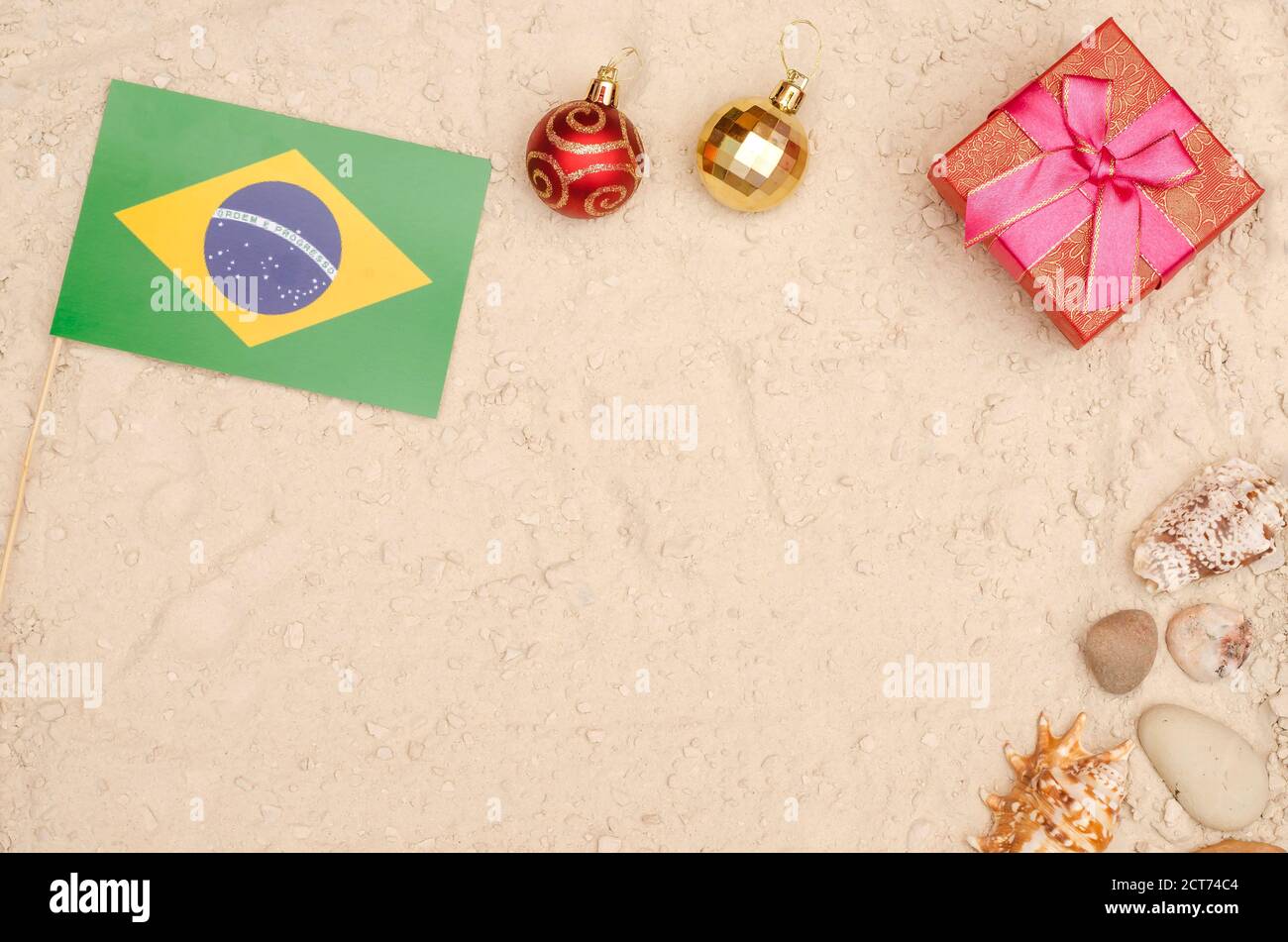 Neujahr und Weihnachtsferien in Brasilien. Brasilien Flagge am Strand mit einem Geschenk mit Kopierplatz Stockfoto