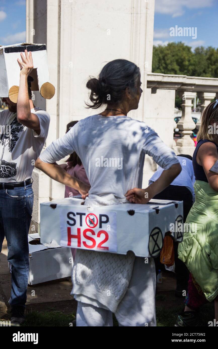 St. James'Park, London, Großbritannien. Eine Frau schaut sich um, während STOP HS2-Demonstranten sich wie ein menschlicher Zug kleiden, um auf der Straße aufzutreten Stockfoto