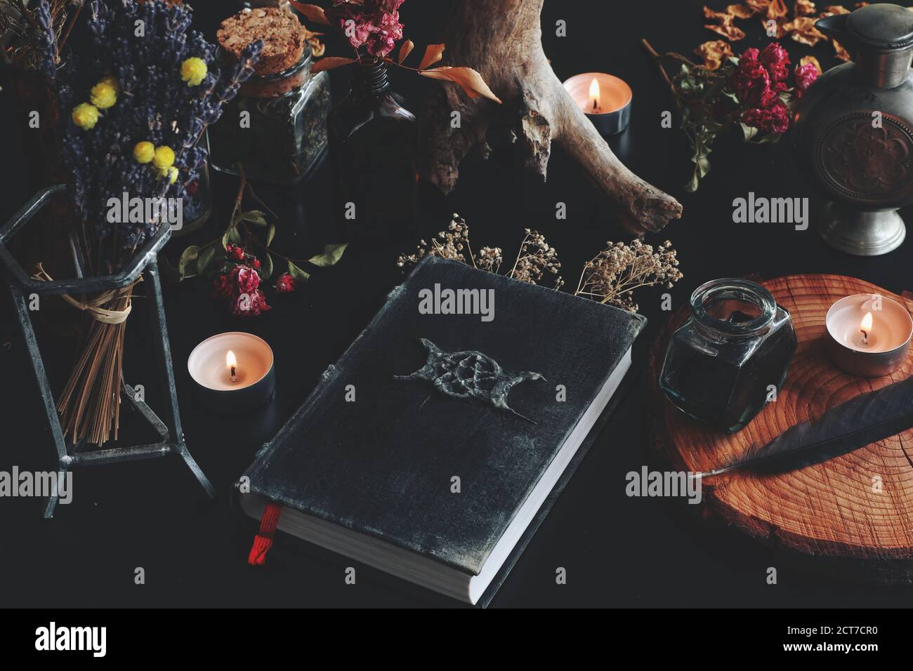 Wiccan Hexenaltar mit Hand gemacht alt aussehende Buch Grimoire mit dreifachen Mond-Symbol, und andere verschiedene Gegenstände Stockfoto
