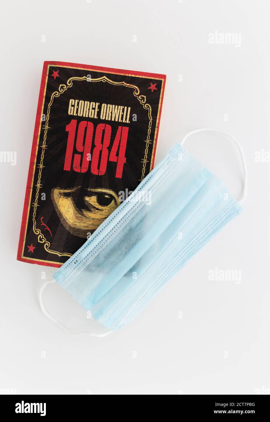 1984 von George Orwell bedeckt mit einer Gesichtsmaske während der Coronavirus-Angst von 2020. Stockfoto