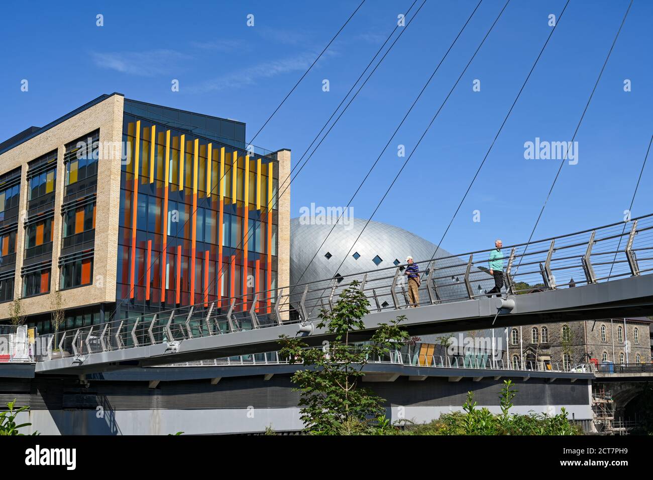 Pontypridd, Wales - September 2020: Menschen, die über die Fußgängerbrücke über den Fluss Taff zu Büros in der neuen Taff Vale Entwicklung in Pontypridd gehen Stockfoto