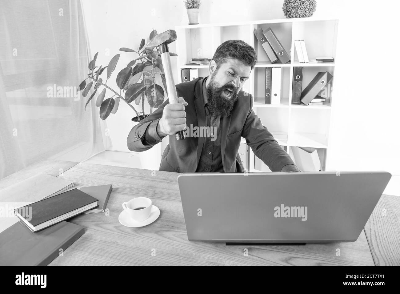 Gesichtsausdruck. Stress und Druck am Arbeitsplatz. Geschäftsmann mit Hammer. Frustrierte Büroangestellte. Veraltete Software. Kampf um den Erfolg. System fatal Problem. Office-PC wird aufgehängt. Stockfoto