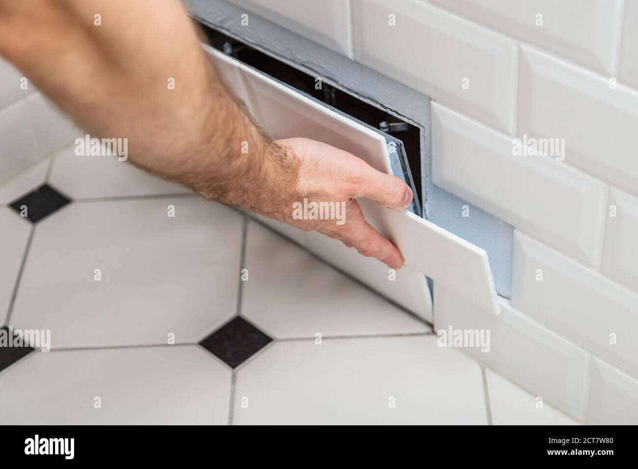 Versteckte revision Sanitär Klappe auf der Wand der Kachel Öffnen unter der Badezimmer Stockfoto