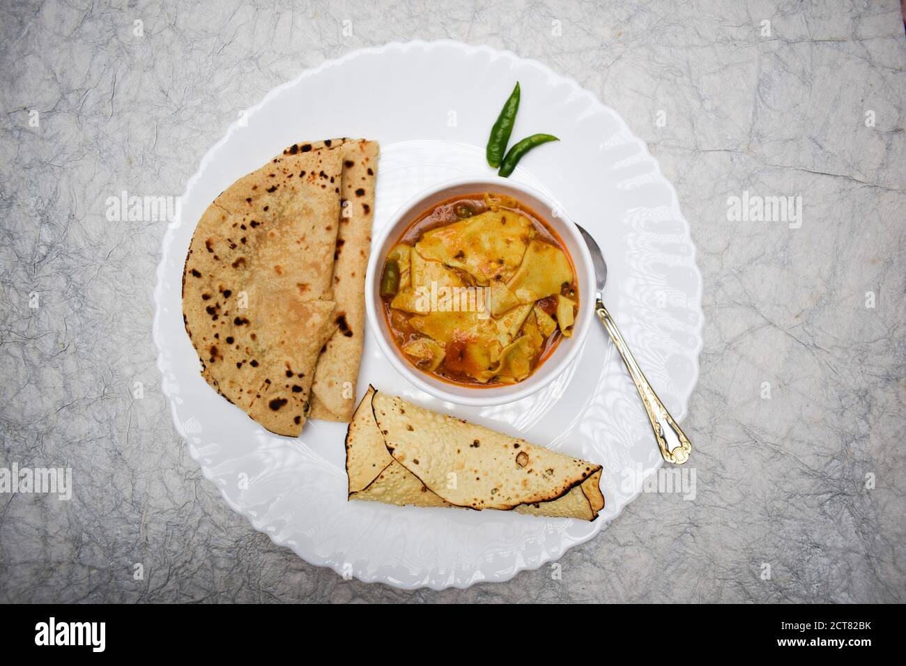 Papad KI sabji in einer Schüssel serviert mit Roti und gerollten Pappadam und grün kühl in Teller Schüssel Löffel. Traditionelles indisches Essen zum Mittag- oder Abendessen Stockfoto