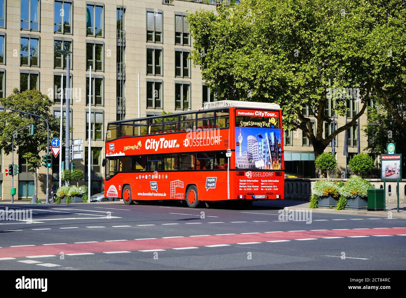 Rote Doppeldecker-Stadtrundfahrt 'Hop on / Hop off'-Bus wartet an einer Haltestelle in der Königsallee in Düsseldorf, Deutschland. Stockfoto