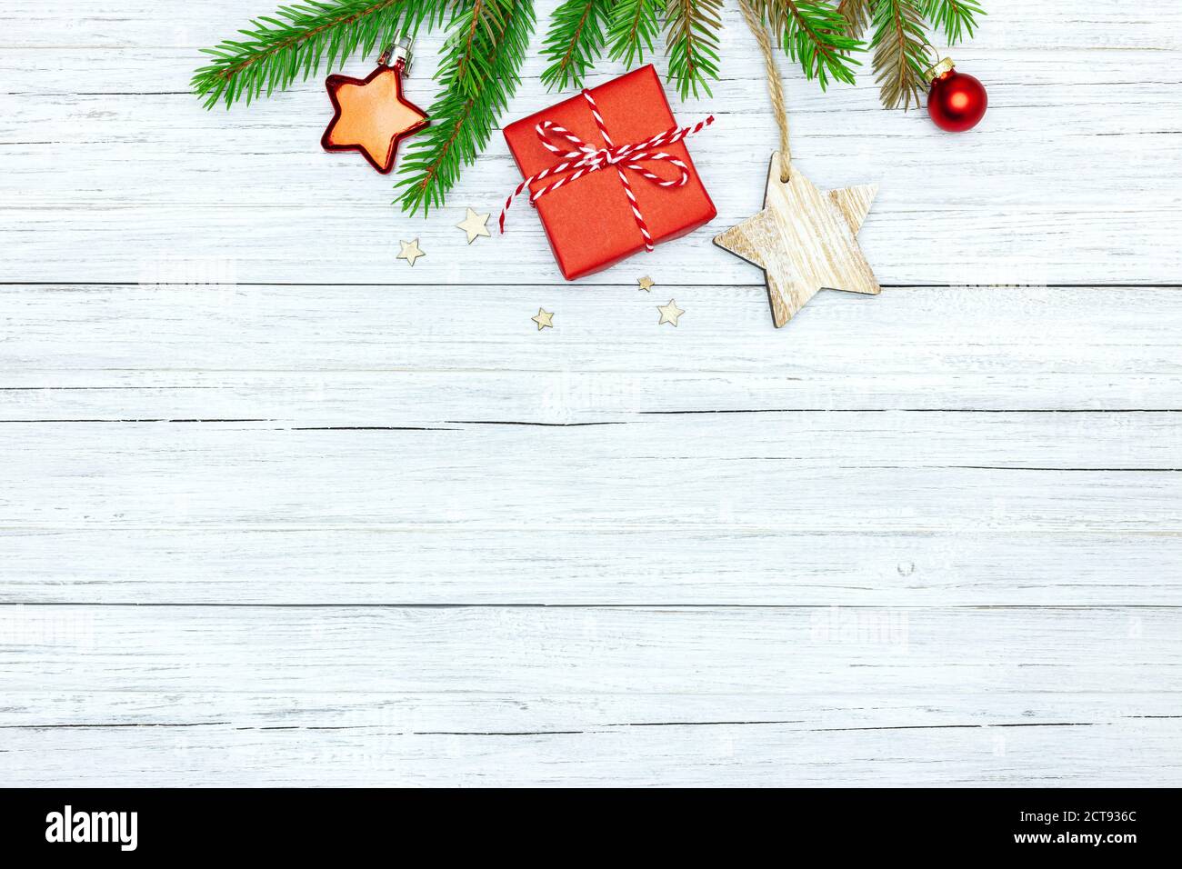 Weisse Holz festlichen Winter Hintergrund mit grünen Tannenbaum Zweig, rote kleine Geschenkbox und weihnachtsdekorationen Stockfoto