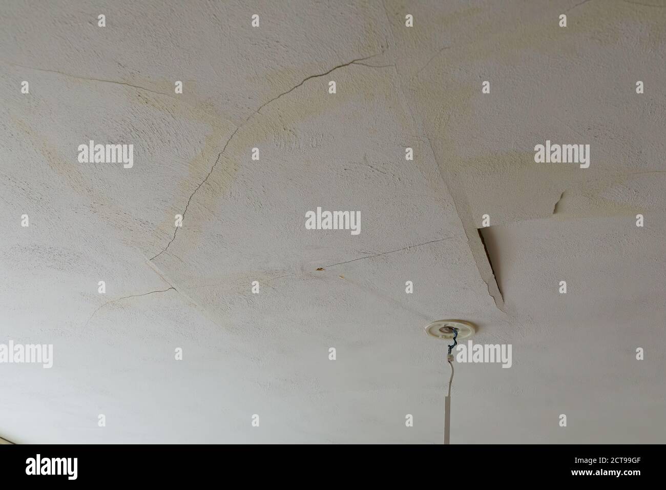 Eine verputzte Hausdecke durch ein Wasserleck gebrochen. Regen oder Leitungswasser verursacht schwere Schäden. Stockfoto