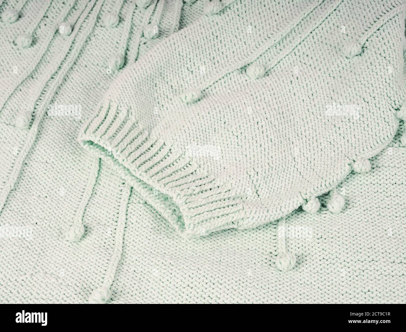 Abstrakt gestrickter Hintergrund. Wollpullover mit Ärmeln. Nahaufnahme des Strickmusters. Stockfoto