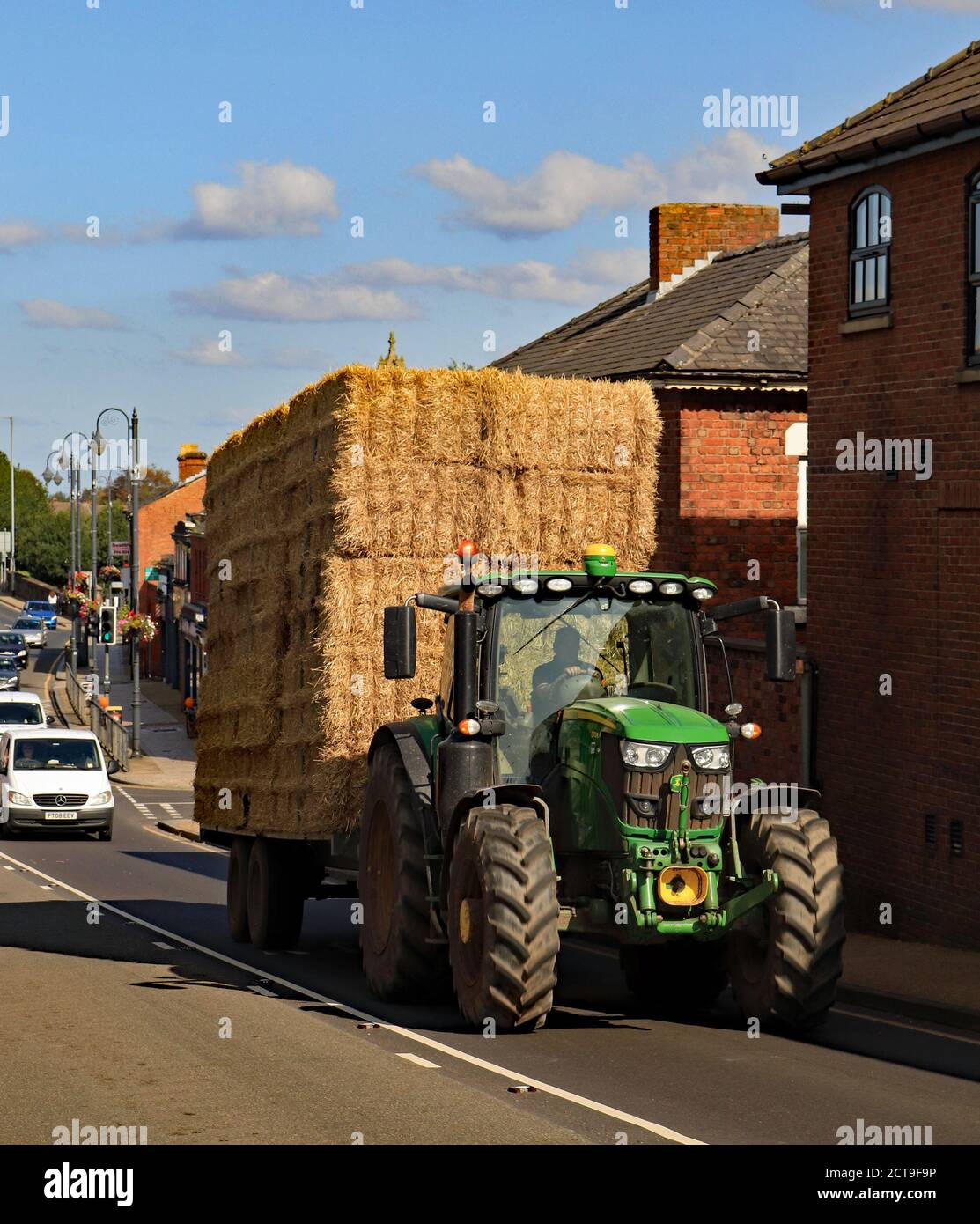 Frühherbst in Burscough als Traktor und Anhänger macht seinen Weg auf die Brücke über den Kanal mit einer Ladung Stroh für die Lagerung in einer Scheune. Stockfoto