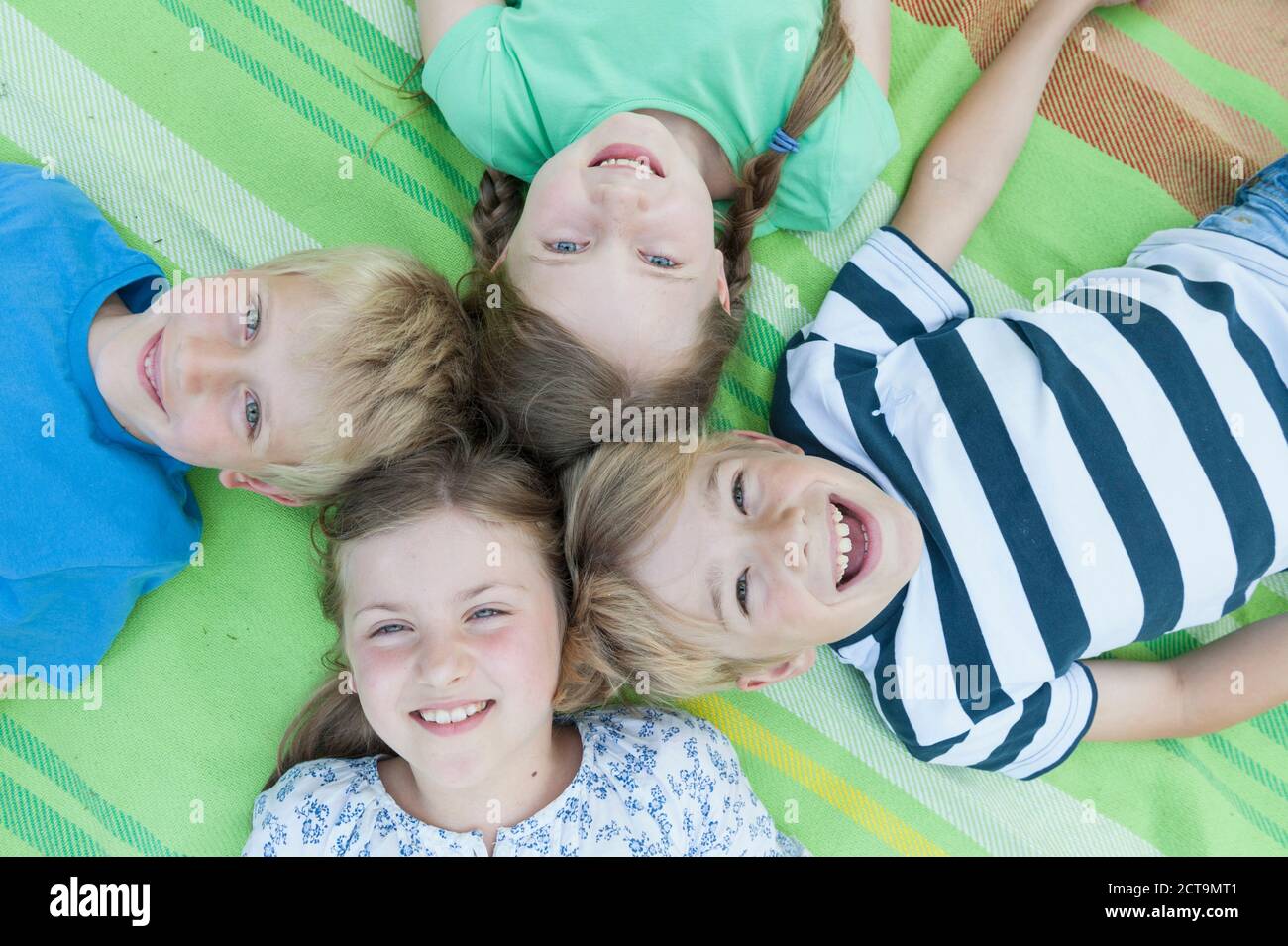 Deutschland, Bayern, vier lächelnden Kindern liegen auf einer Decke Stockfoto