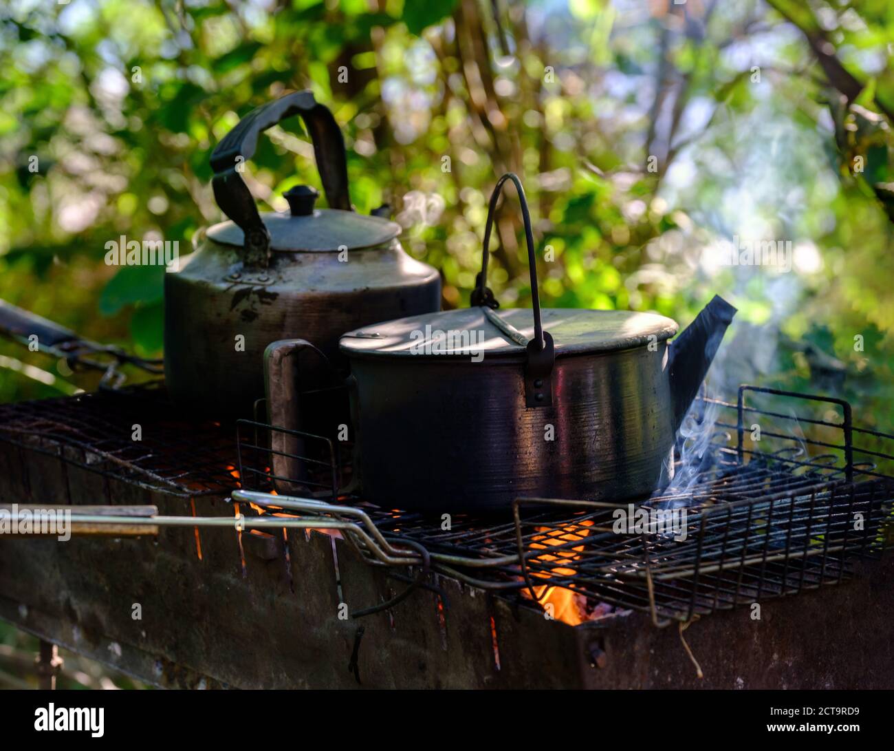 Wasserkocher am Kamin für Tee und Kaffee. Heißer und aromatischer Kaffee mit Wasserkocher Stockfoto