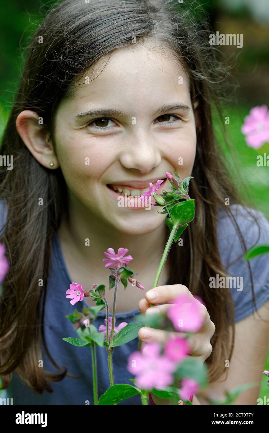 Mädchen riecht an eine Frühlingsblume Stockfoto