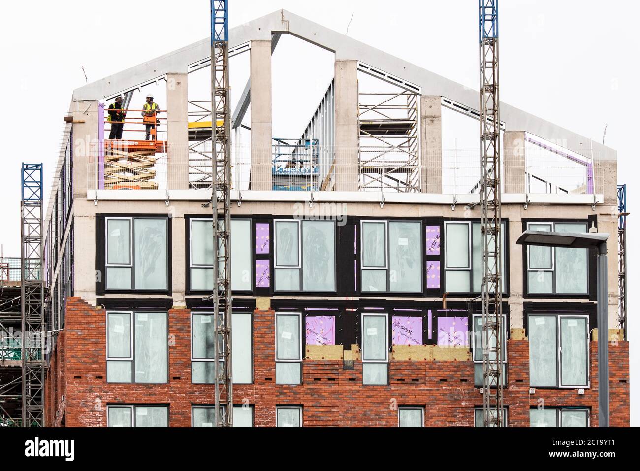 Zwei Arbeiter, die einen Dachabschnitt in einem Gebäude in der Shadwell Street in der Nähe des Stadtzentrums von Birmingham installieren. Stockfoto