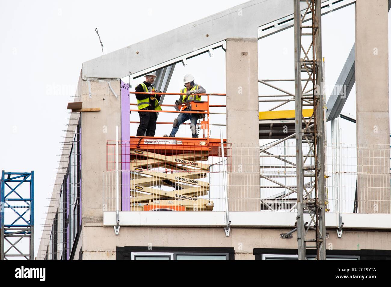 Zwei Arbeiter, die einen Dachabschnitt in einem Gebäude in der Shadwell Street in der Nähe des Stadtzentrums von Birmingham installieren. Stockfoto
