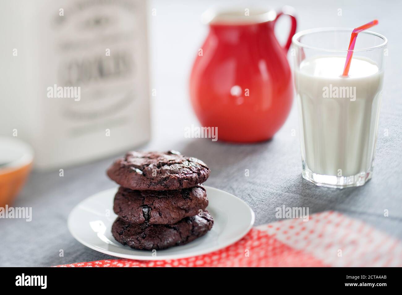 Schokoladenkekse mit getrockneten Sauerkirschen und ein Glas Milch Stockfoto