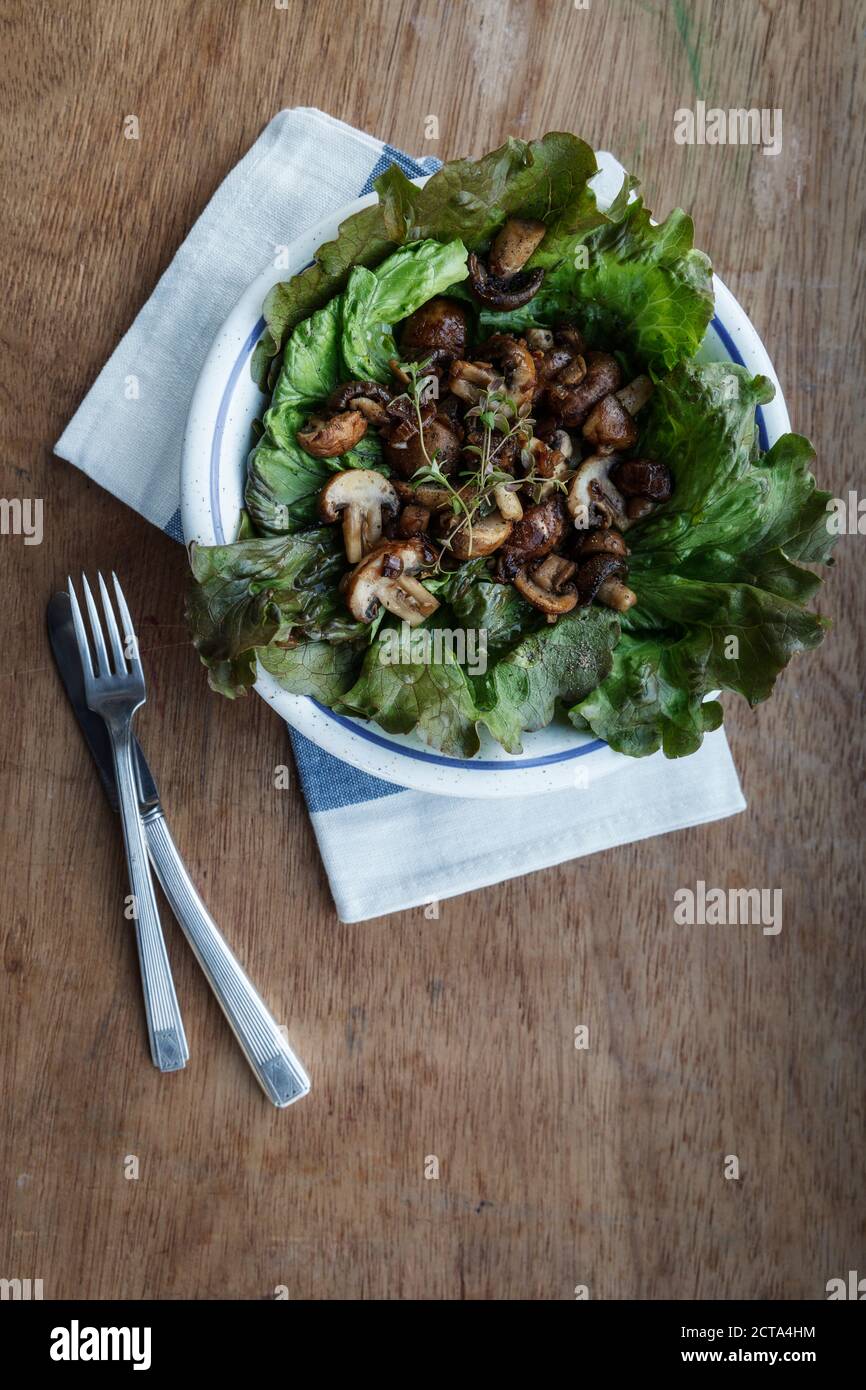 Teller mit gebratenen Champignons auf Blattsalat Stockfoto