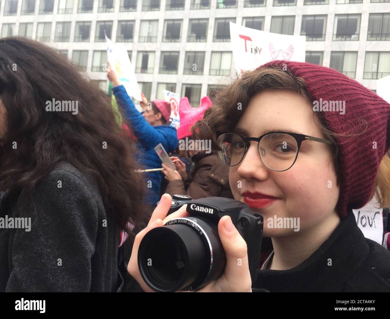 01/21/2017 Washington DC, USA: Frauenmarsch - Junge Fotografin marschiert in Massendemonstration, umgeben von Aktivisten. Stockfoto