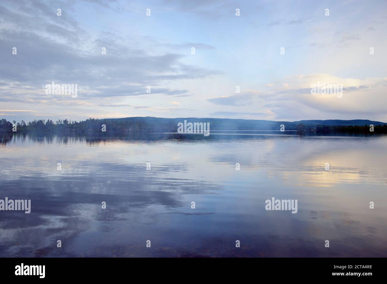 Schweden, Stroemsund, Sonnenuntergang an einem See und Rauch von einem Lagerfeuer Stockfoto