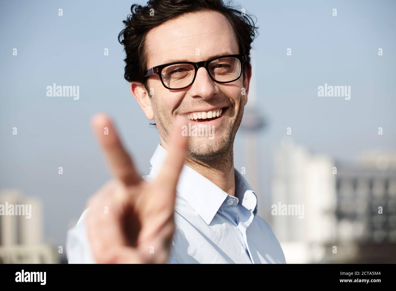 Porträt von lächelnden Mann zeigt Victory-Zeichen Stockfoto