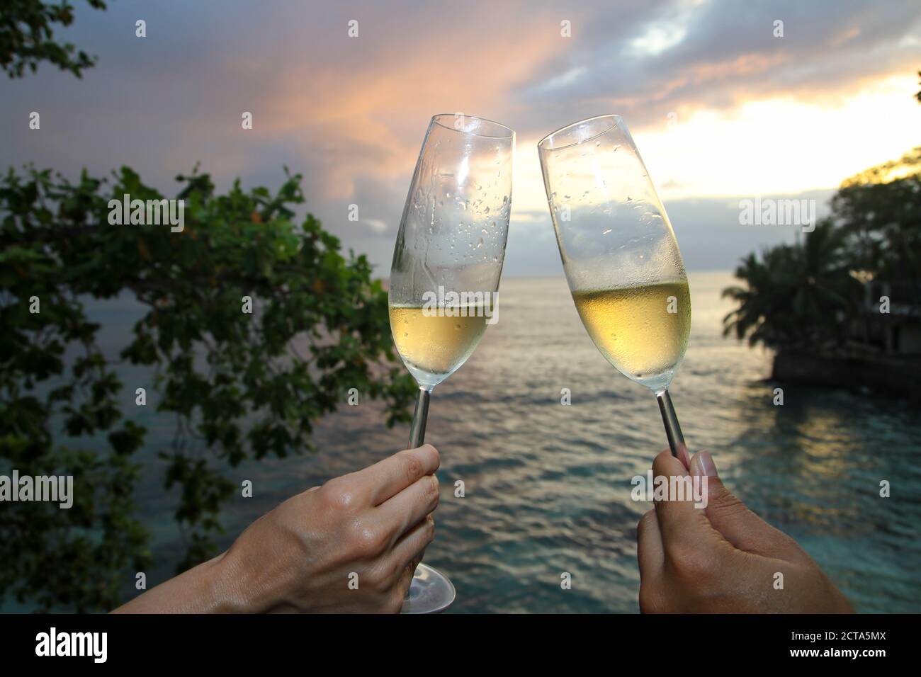 Zwei Personen halten Sie Champagner Flöten an Strand Stockfoto
