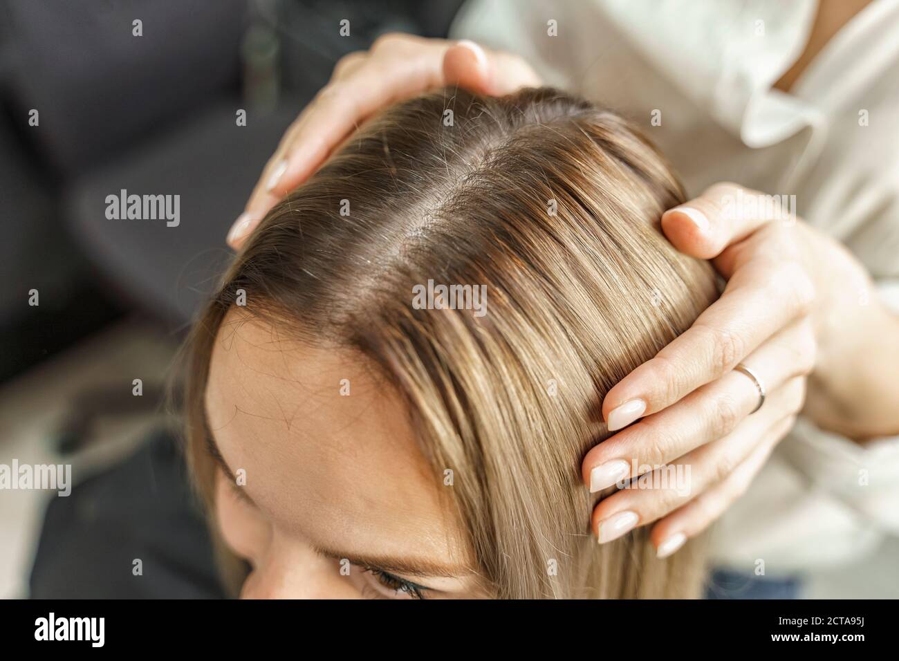 Nahaufnahme des blonden Kopfes einer Frau mit geteilten Haaren wachsen Wurzeln zurück. Haircare, so dass neue Frisur, Haartherapie Konzept Stockfoto