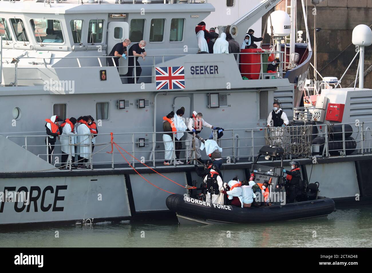 Eine Gruppe von Menschen, die als Migranten gedacht werden, steigen an Bord des HMC Seeker aus, während sie an Bord einer Border Force Rippe in Dover Marina in Kent klettern, nach einem kleinen Bootsunfall im Ärmelkanal. Stockfoto