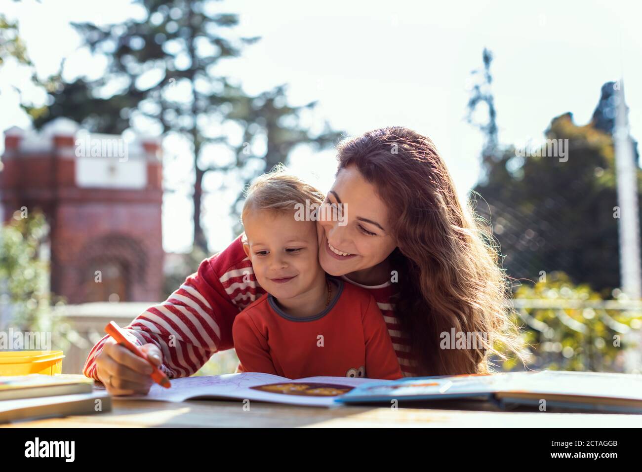 Sonnentag, Mutter und Sohn machen Zeichnungen im Garten Auf dem Picknicktisch Stockfoto