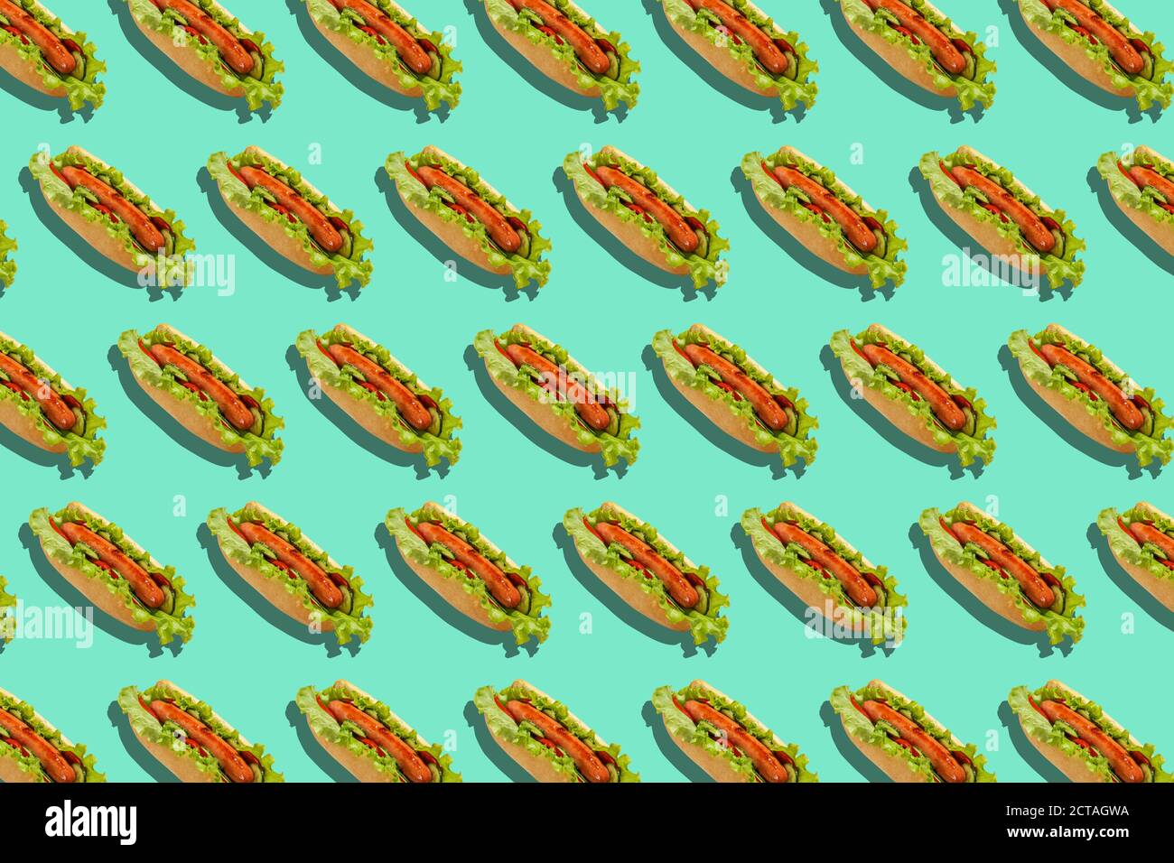 Gesunde Fast Food und Lieferung für die Party. Hot Dogs mit Würstchen, Salat und Gemüse auf türkisfarbenem Hintergrund Stockfoto