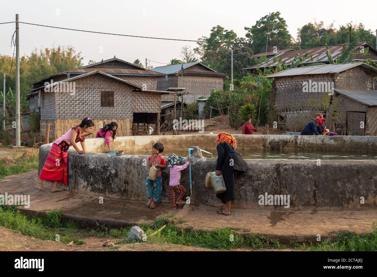 Frauen holen Wasser mit Plastikdosen am Dorfreservoir in Burma, Myanmar Stockfoto