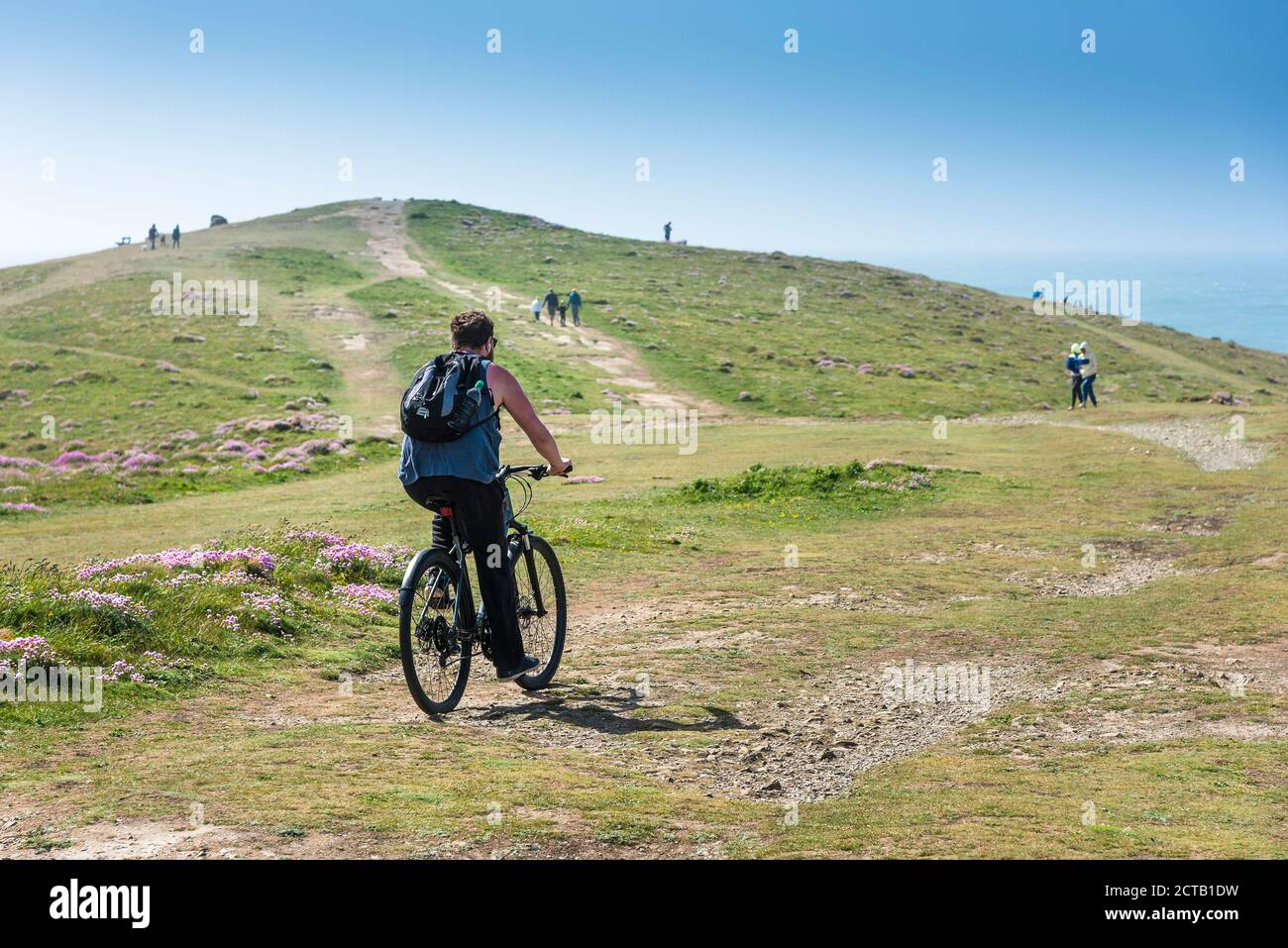 Ein Radfahrer, der auf seinem Mountainbike entlang des gesamten Point East in Newquay in Cornwall fährt. Stockfoto