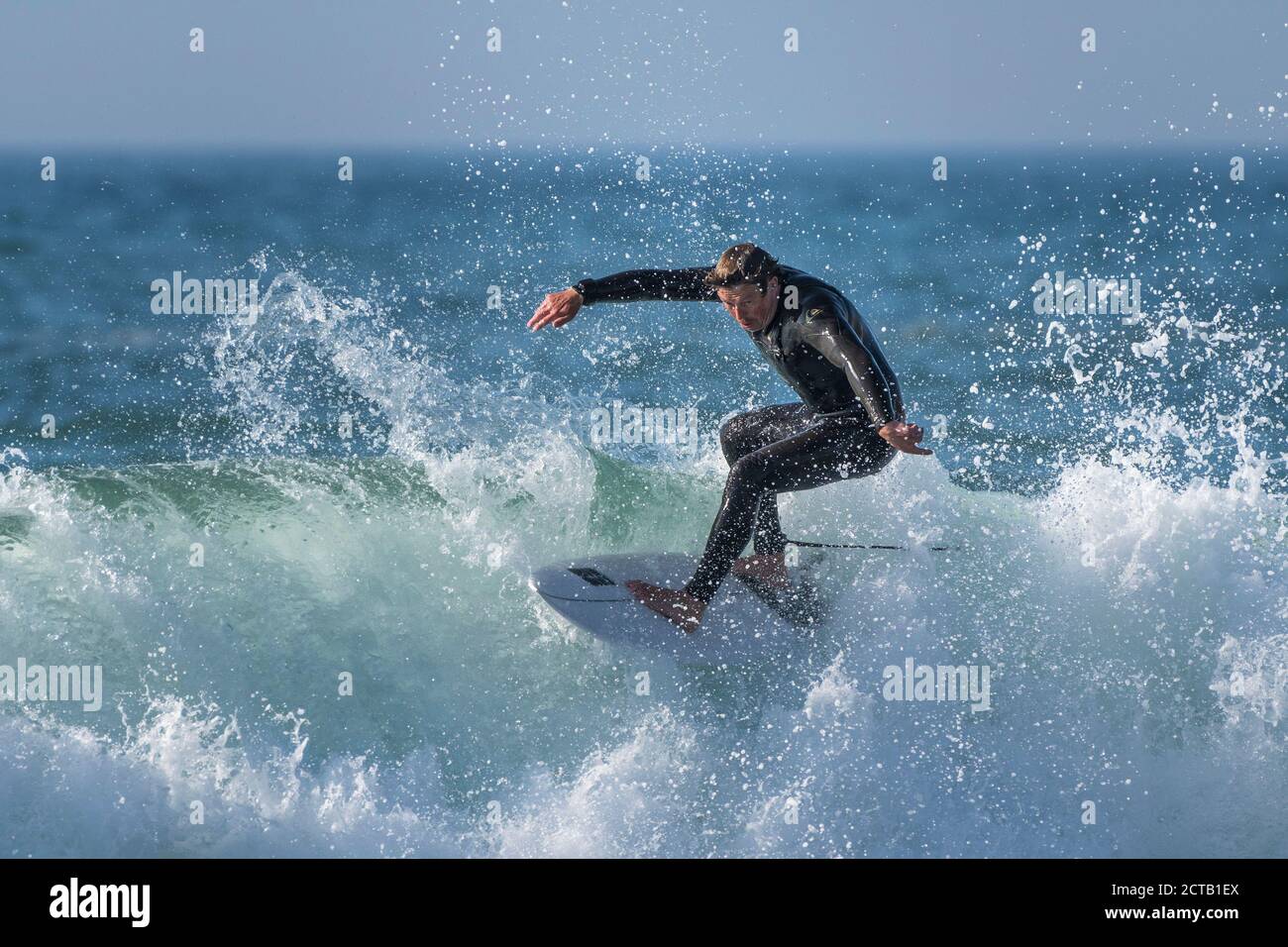 Spektakuläre Surfaktion als reifer Surfer reitet eine Welle am Fistral in Newquay in Cornwall. Stockfoto
