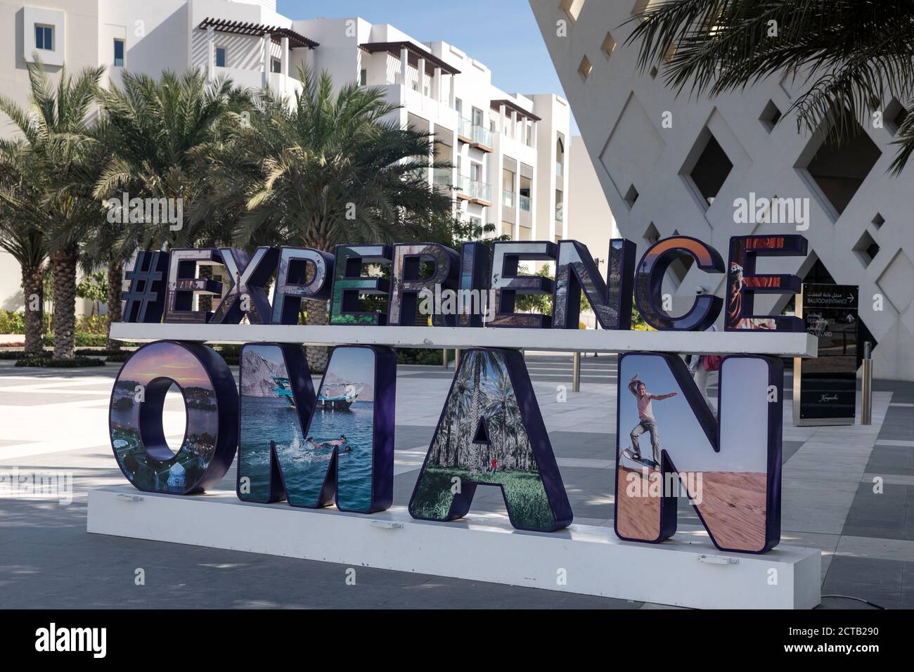 Sign post 'Experience Oman' vor dem Kempinski Hotel in Al Mouj, The Wave, Muscat, Sultanat von Oman. Stockfoto