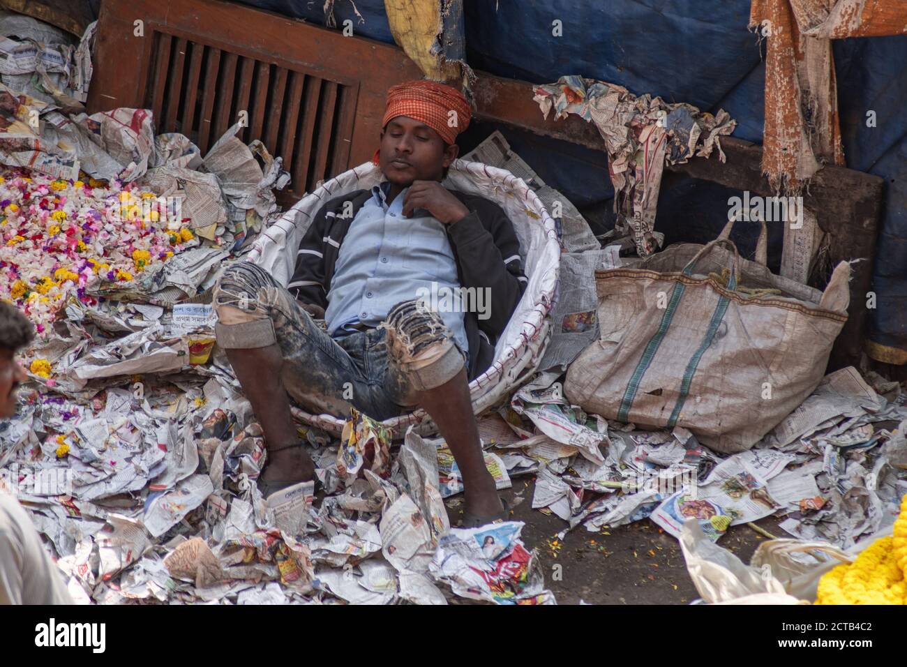 Kolkata, Indien - 2. Februar 2020: Ein nicht identifizierter Mann schläft und ruht auf einer Menge Zeitung auf Mallick Ghat Blumenmarkt am 2. Februar 2020 Stockfoto
