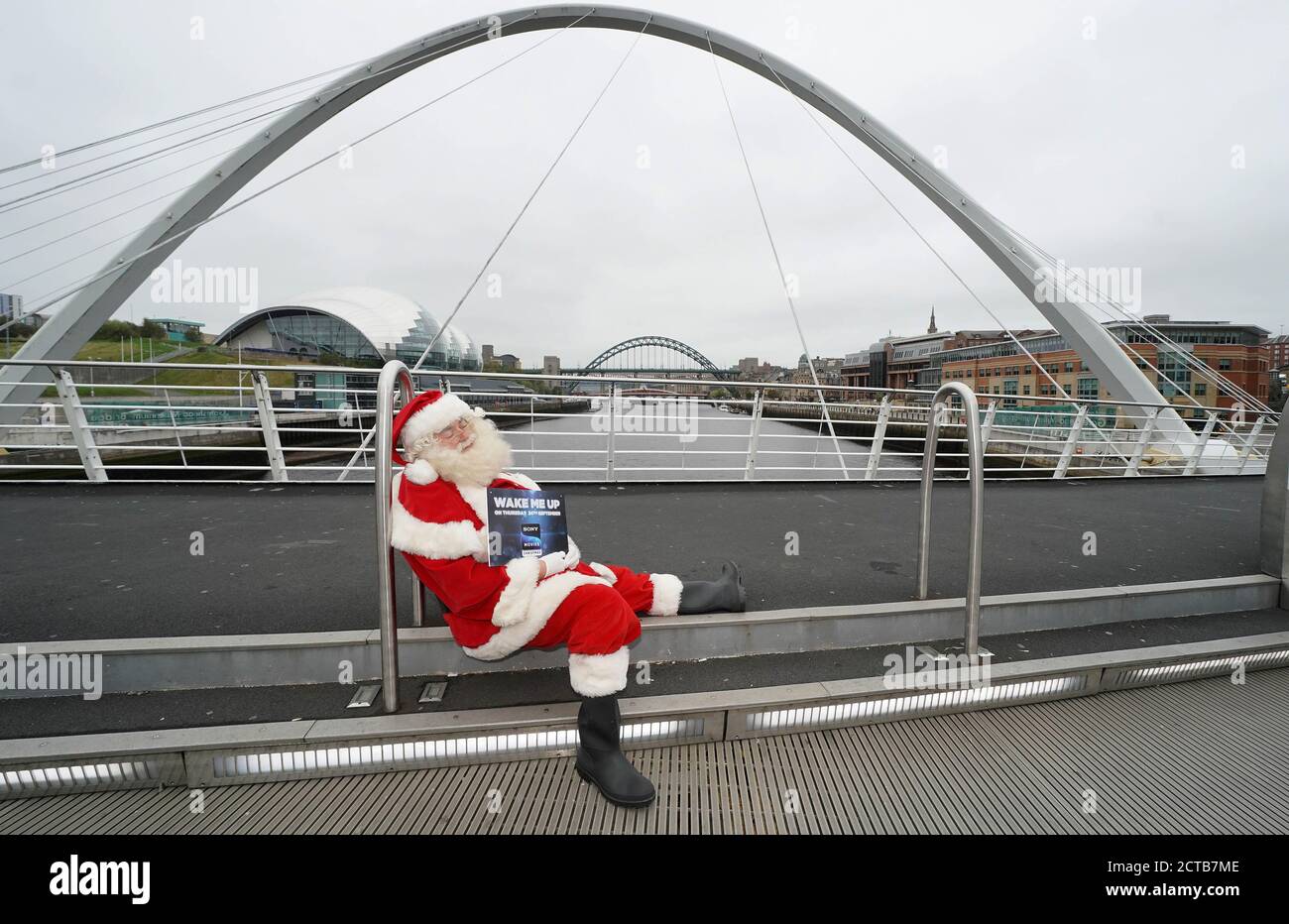 Ein Mann, der als Weihnachtsmann gekleidet ist, bittet Passanten in Newcastle, ihn rechtzeitig zur Vorstellung des Weihnachts-Fernsehsenders Sony Movies, der am 24. September live geht, „aufzuwecken“. Stockfoto