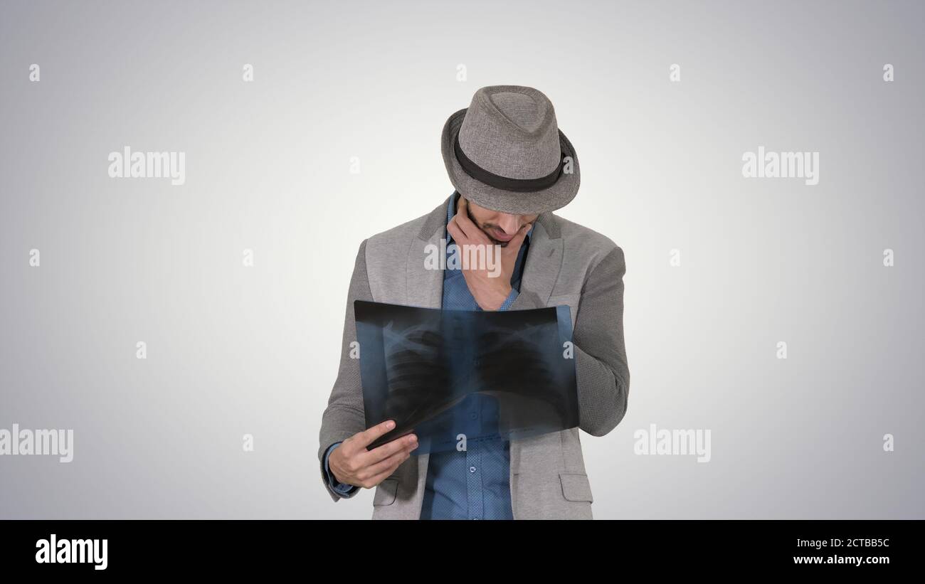 Casual Mann Blick auf Röntgenaufnahme der Lunge und zu Fuß auf Gradientenbac Stockfoto