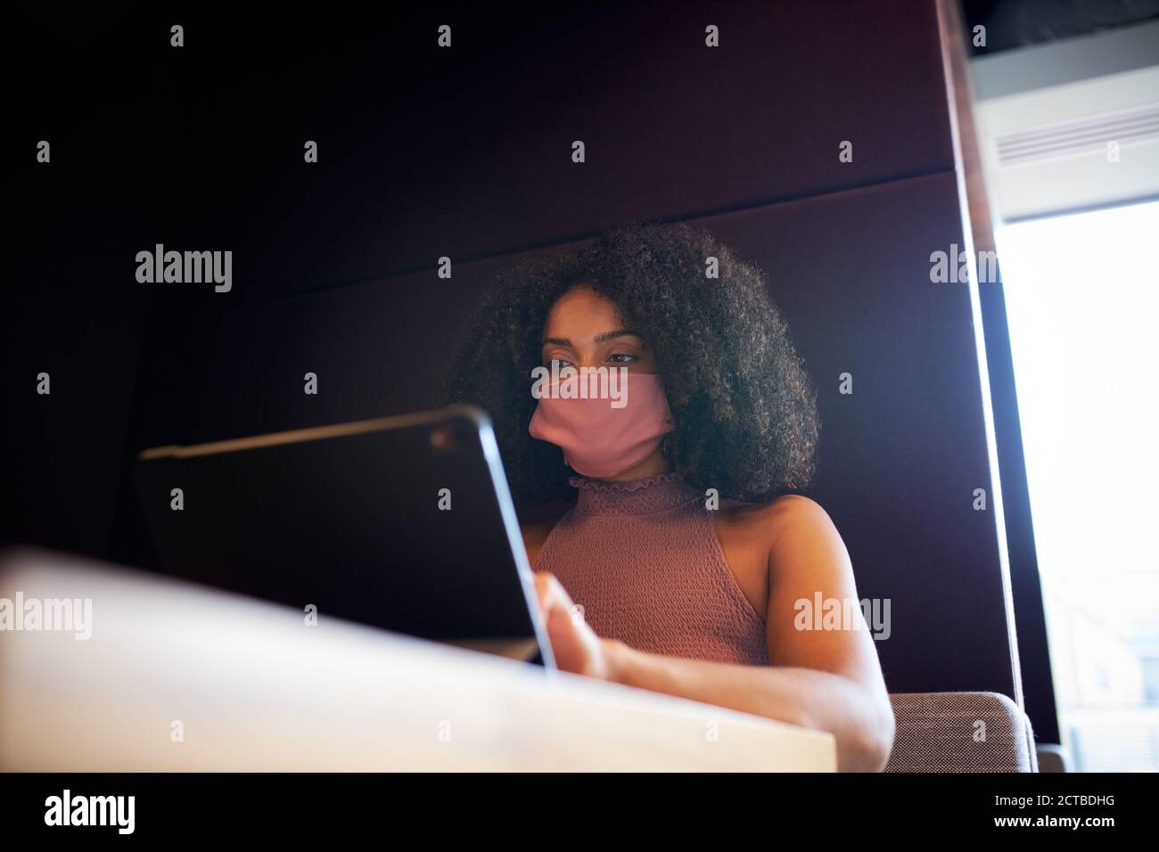 Geschäftsfrau Trägt Maske Arbeitet In Sozial Distanzierten Kabine Im Büro Während Der Gesundheitsinpandemie Stockfoto