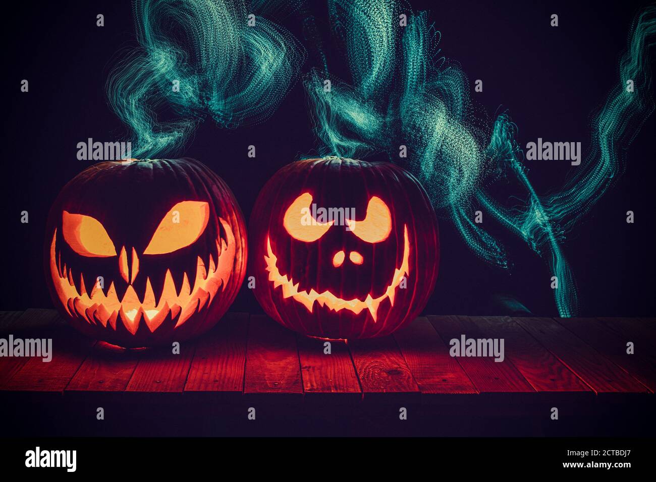 halloween Laternen geschnitzt auf Holz mit beweglichen Lichtern im Hintergrund. Stockfoto