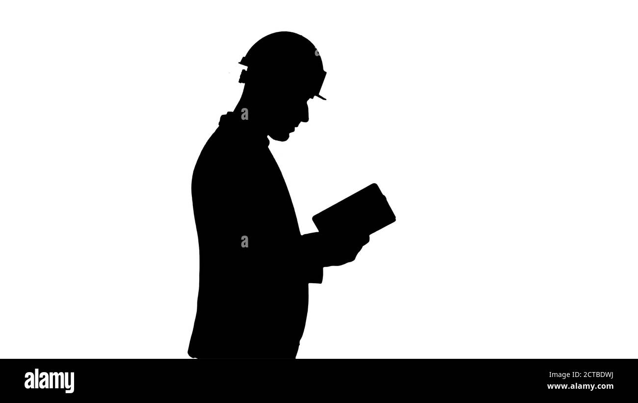 Silhouette junger Architekt liest Lehrbuch oder Notizbuch beim Gehen. Stockfoto