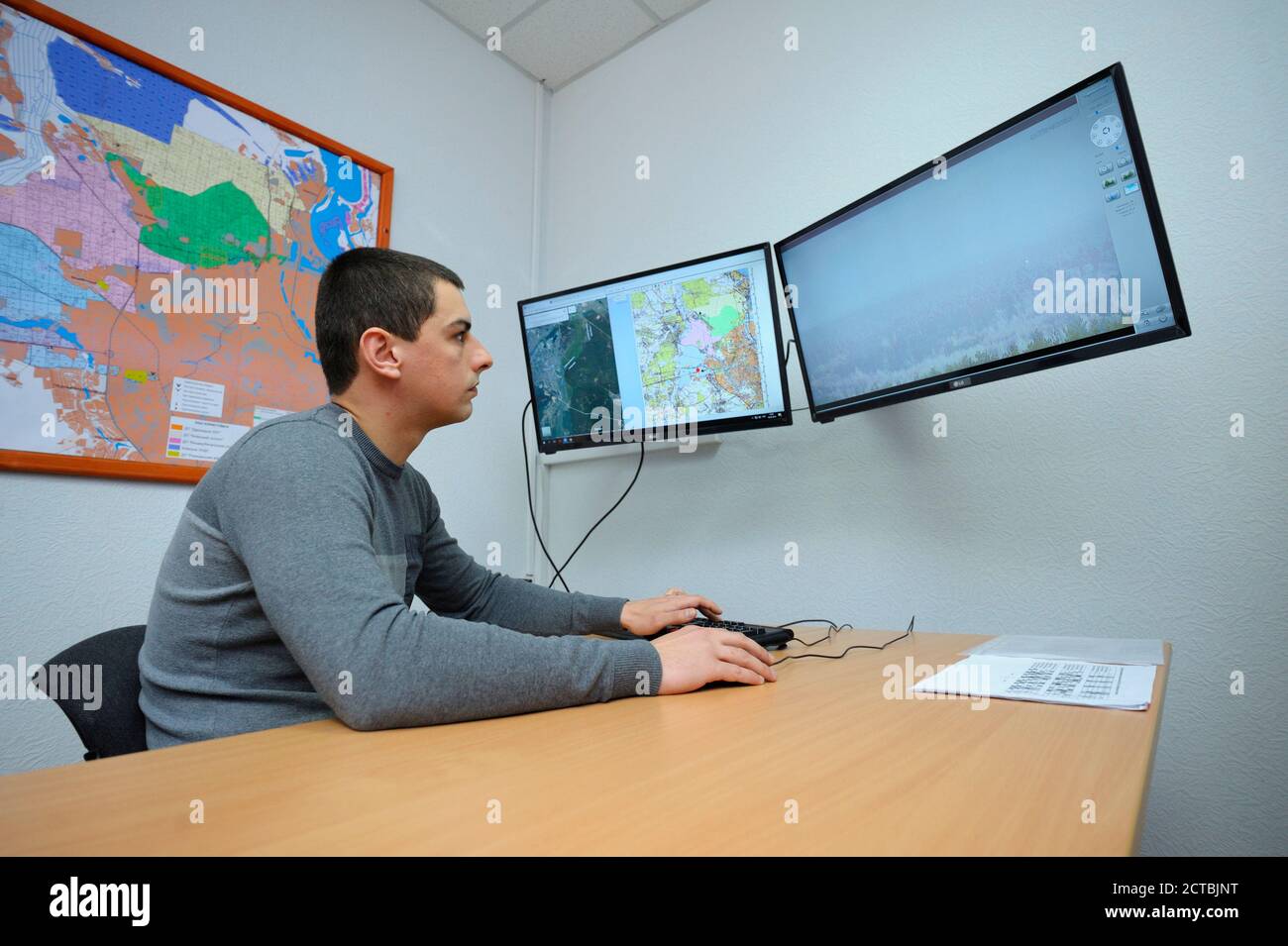 In der Feuerwache Videoüberwachungsraum: Bediener sitzt vor Monitoren beobachten Brandgefahren in Wäldern Stockfoto
