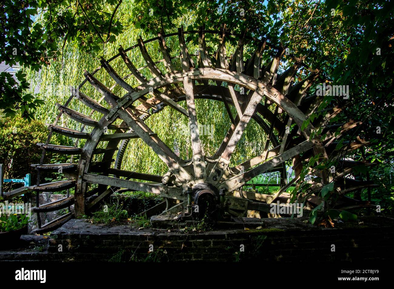Altes Radelrad auf dem Fluss im Garten. Stockfoto