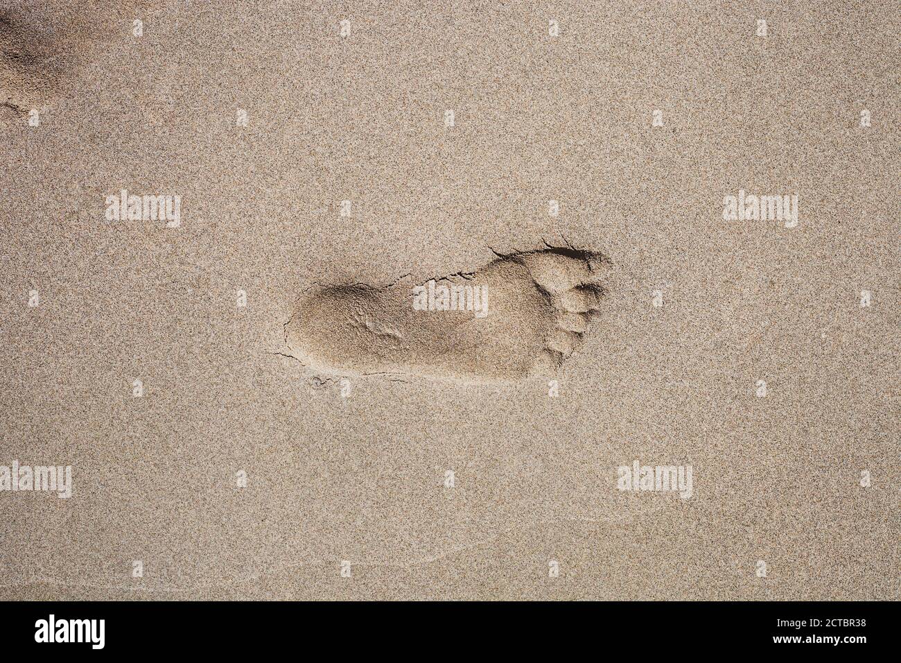 Aufdruck des rechten menschlichen Fußes im Sand. Mans Fußabdruck auf Sandstrand Blick von oben, Konzept der allein zu Fuß Stockfoto