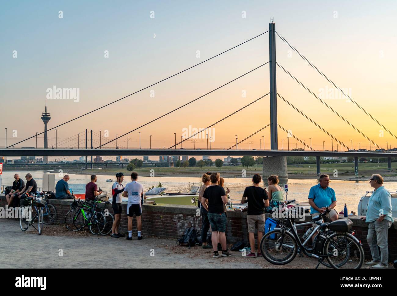 Skyline von Düsseldorf am Rhein, Rheinturm, Oberkassler Brücke, Menschen genießen die Abendstimmung im Sommer, am Rheinufer, Düsseldorf, N Stockfoto