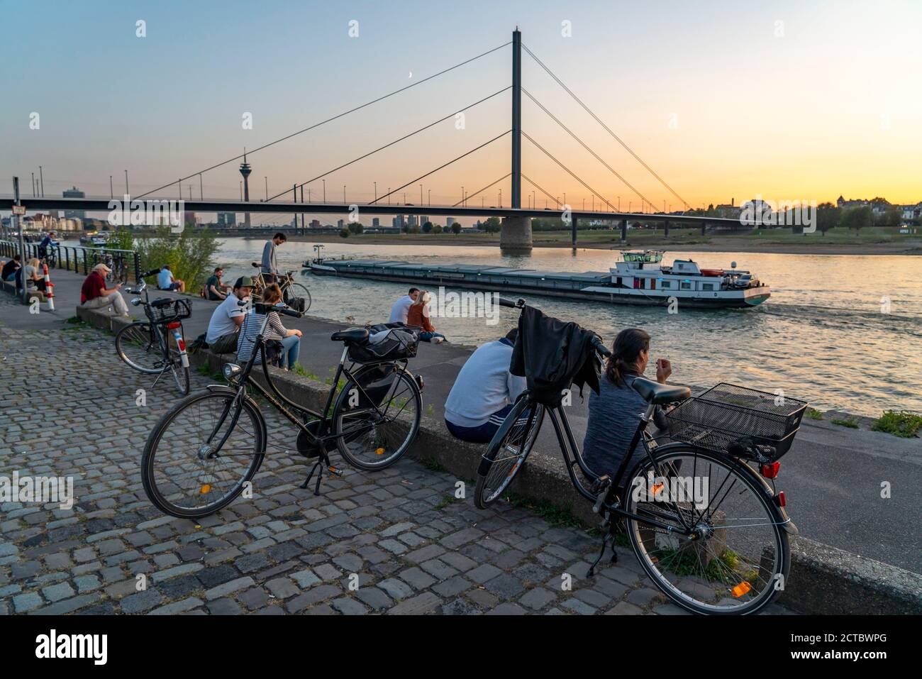 Skyline von Düsseldorf am Rhein, Rheinturm, Oberkassler Brücke, Menschen genießen die Abendstimmung im Sommer, am Rheinufer, Düsseldorf, N Stockfoto