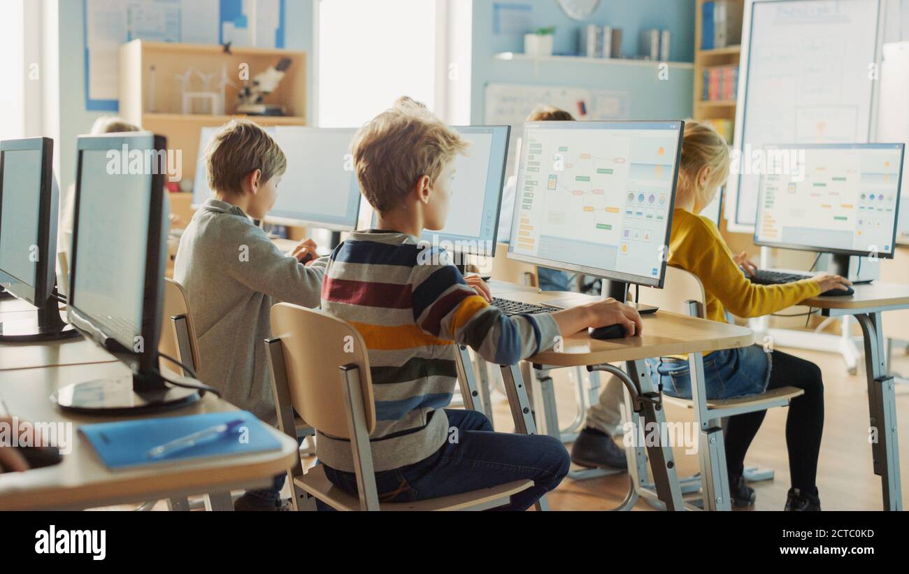 Grundschule Informatik Klassenzimmer: Intelligente kleine Schüler arbeiten an Personal Computers, lernen Programmiersprache für Software-Codierung Stockfoto