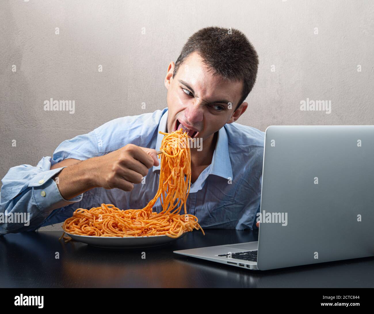 Ein Mann Der Spaghetti Mit Tomatensauce Isst Und Dabei Zuschaut Computer Stockfotografie Alamy