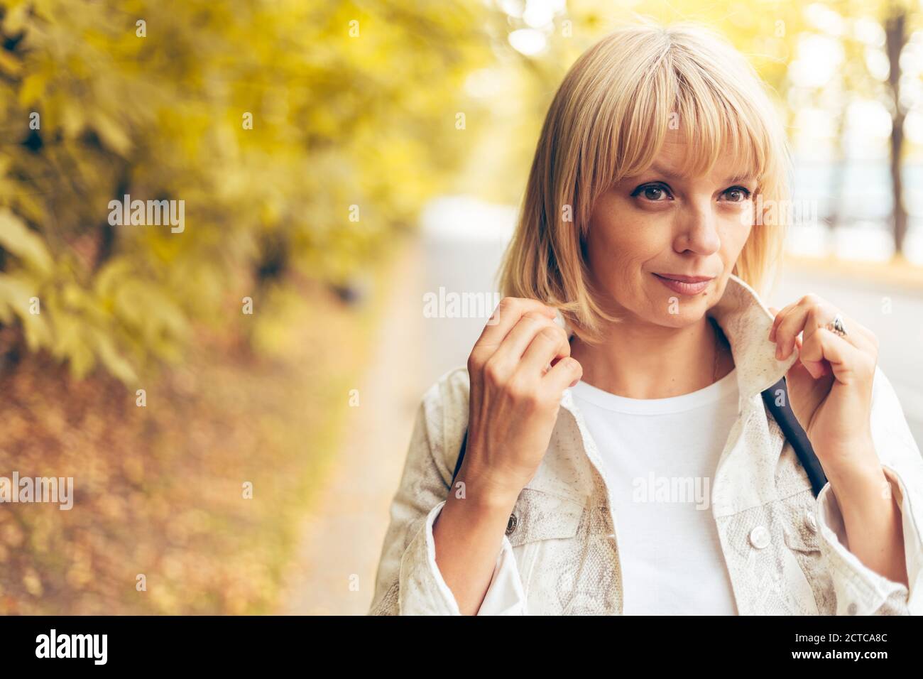 Portrait der schönen blonden erwachsenen Frau im Herbst Park auf dem Naturspaziergang im Freien. Stockfoto