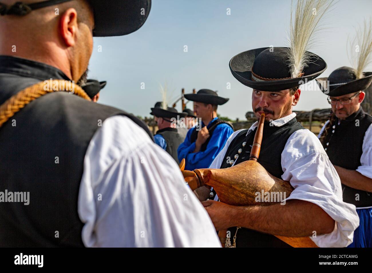 Shepherd spielt auf einem ungarischen Dudelsack, während andere es sind Zuhören Stockfoto