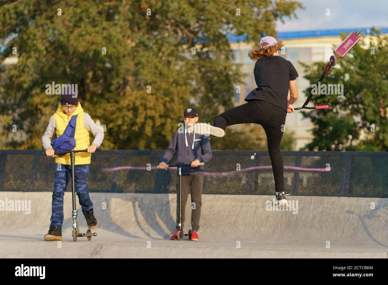 Moskau, Russland - 11. September 2020: Teenager führt einen Trick in der Stadt Skatepark. Roller schieben. Er springt über ein Hindernis. Extremsport ist Stockfoto