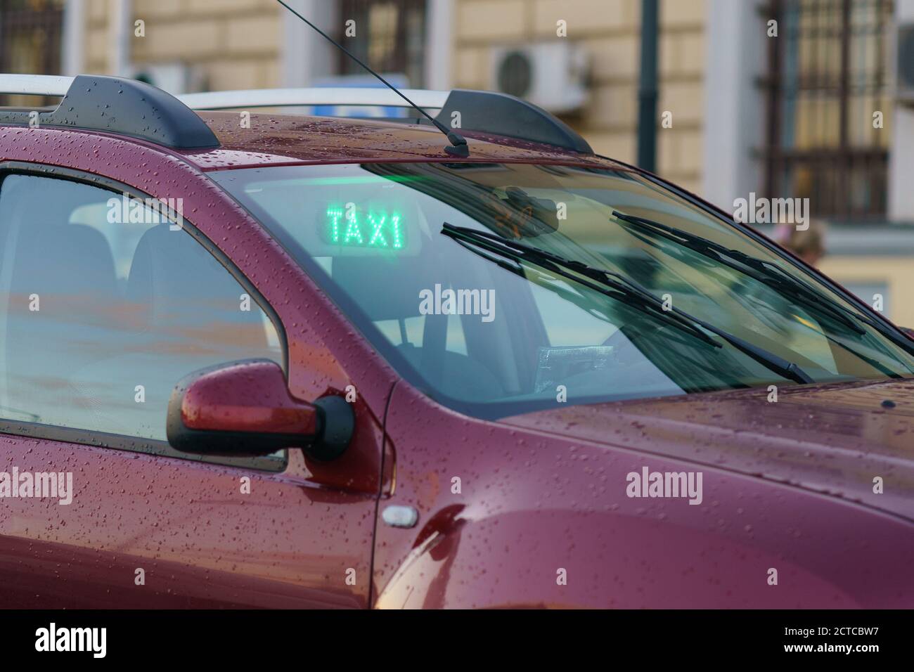 Fotografie des modernen violetten Stadttaxis am Herbsttag in Moskau. Bild mit defokusserem Hintergrund. Thema öffentliche Verkehrsmittel. Frontal Stockfoto